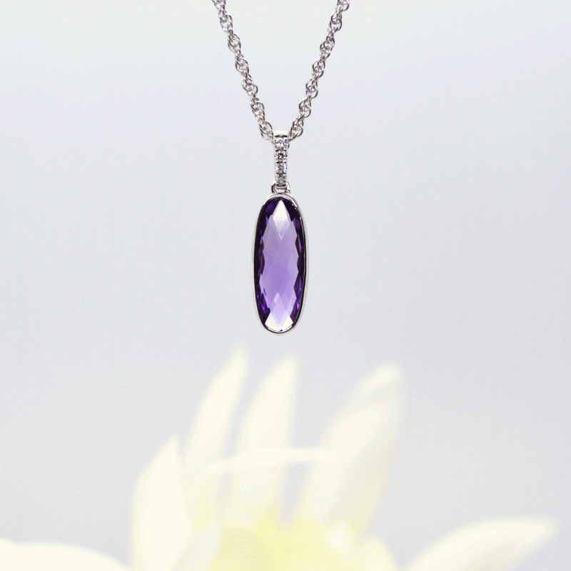 Elongated oval checkerboard-cut amethyst gemstone in 14k white gold pendant with diamond bail. Allison Kaufman