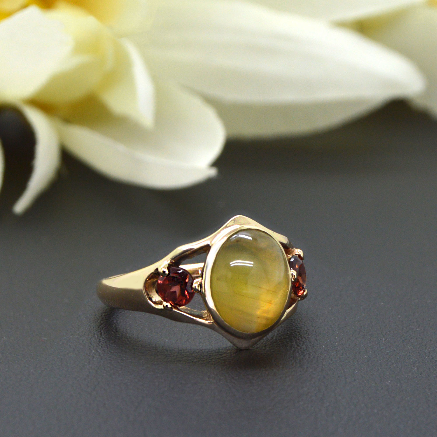 Cat's eye chrysoberyl cabochon oval gemstone with dark red orange spessartite garnets in 14K yellow gold ring, designed by Morgan's Treasure in Westerville, Ohio