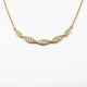 Twist design necklace with pave set diamonds and millgrain detail on 14K yellow gold chain, Allison Kaufman
