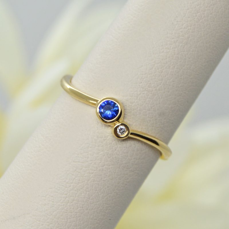 two-stone bezel set ring with sapphire and diamond