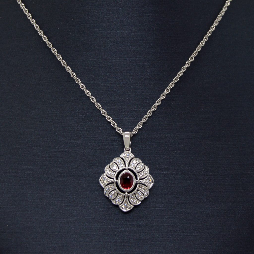 14K white gold diamond necklace with filigree detail and oval ruby in center