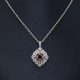 14K white gold diamond necklace with filigree detail and oval ruby in center