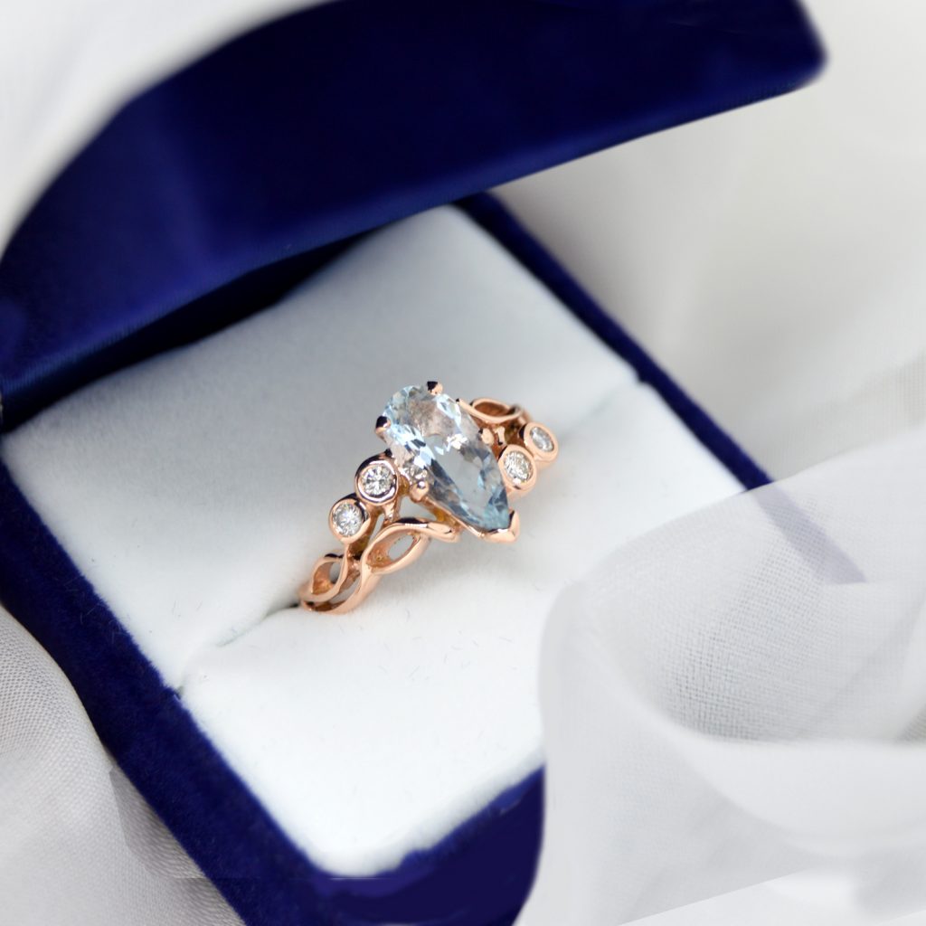 14K rose gold ring designed by Morgan's Treasure with bezel set diamonds in an organic open design with pear cut aquamarine gemstone