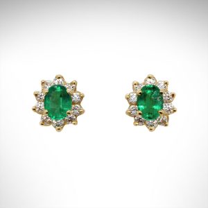 14K yellow gold earrings with oval emeralds and diamond halos.