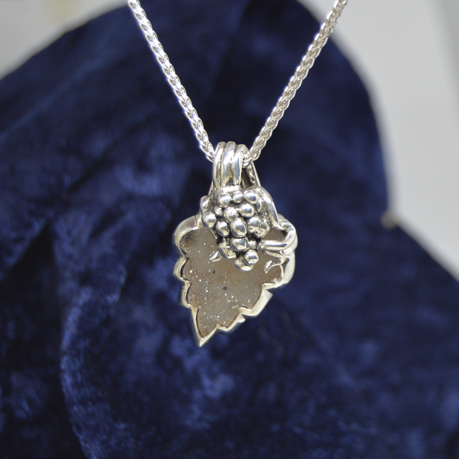 Sterling silver necklace with pendant designed with grape cluster vine and leaf, set with leaf shaped natural druzy gemstone