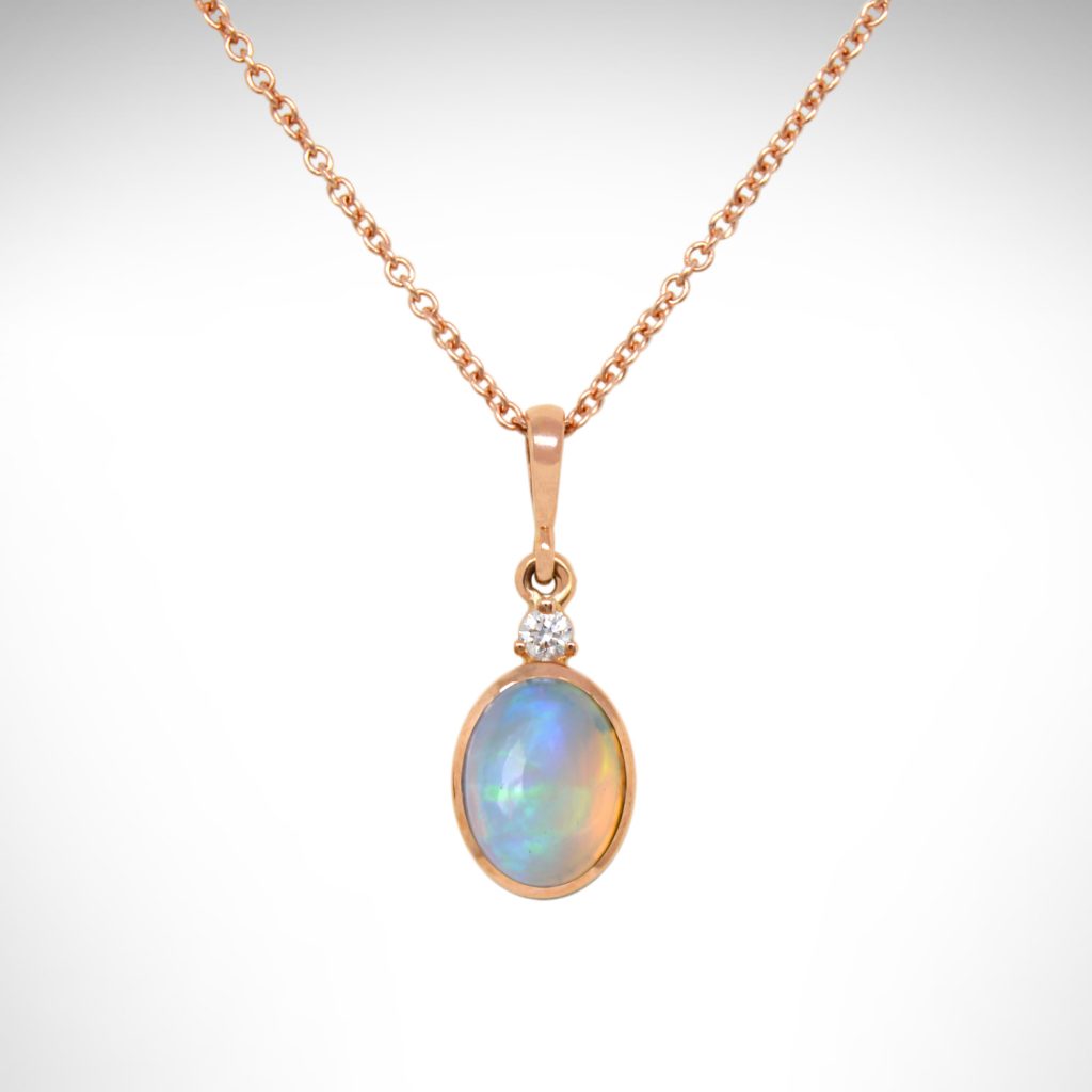 Ethiopian opal oval bezel set dangle necklace in 14k rose gold with an accent diamond