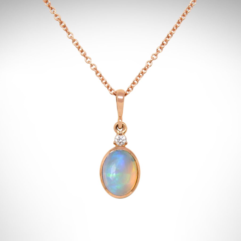 Ethiopian opal oval bezel set dangle necklace in 14k rose gold with an accent diamond