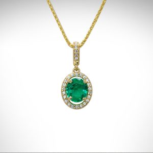 14ky gold emerald and diamond pendant with diamond halo and diamond bail on a yellow gold chain
