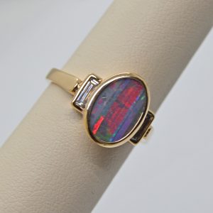 Australian Boulder Opal natural oval gemstone, bezel set oval three stone ring with baguette diamonds in 14k yellow gold ring. Designed by Morgan's Treasure in Westerville, OH