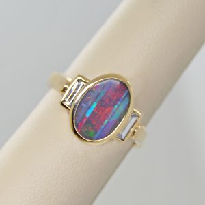 Australian Boulder Opal natural oval gemstone, bezel set oval three stone ring with baguette diamonds in 14k yellow gold ring. Designed by Morgan's Treasure in Westerville, OH