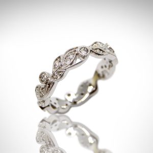 Carizza eternity band, a vine design with diamonds and millgrain in 18K white gold