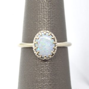 14K white gold ring with crown style prong setting and oval cabochon opal gemstone