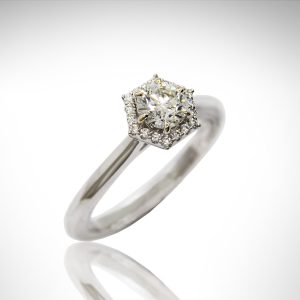 Hexagon halo engagement ring with round brilliant diamond, 6 prongs, white gold with true french pave-set diamonds.