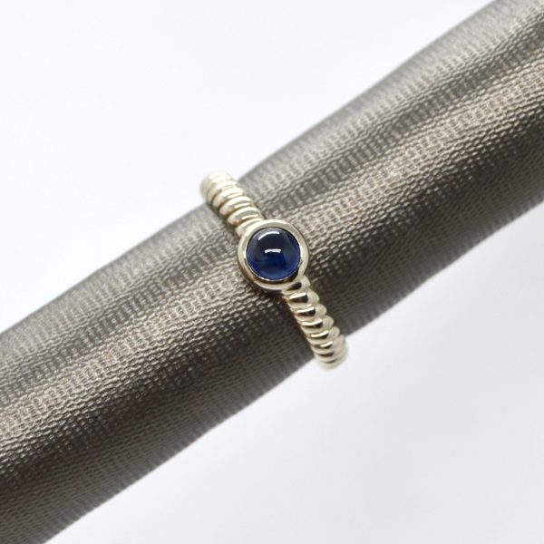 14K white gold ring with rope style shank and bezel set cabochon blue sapphire