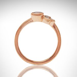 14k rose gold diamond ring with bezel-set round and marquise diamonds and simple band, minimalist design with floral/ leaf inspiration.