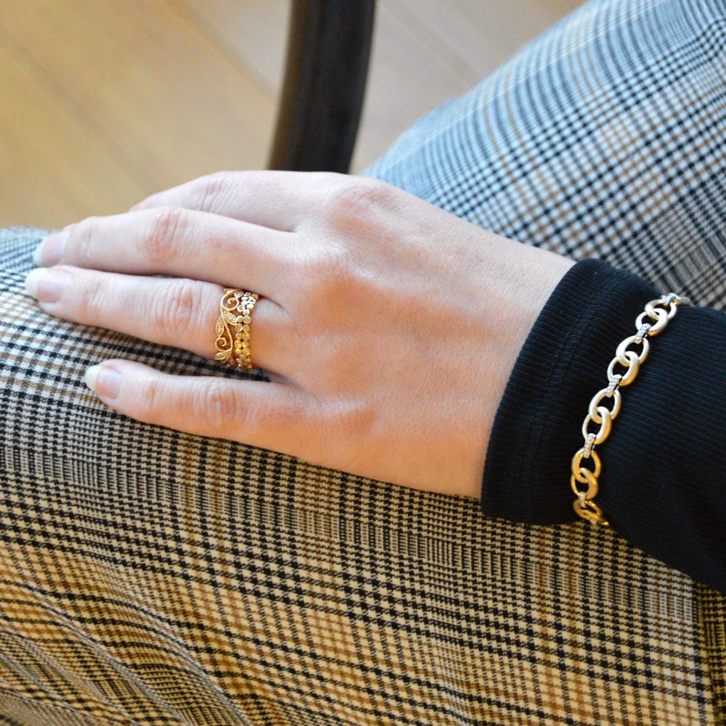 Model wearing 2 14KY stackable diamond rings and two tone diamond and gold link bracelet with brushed finish