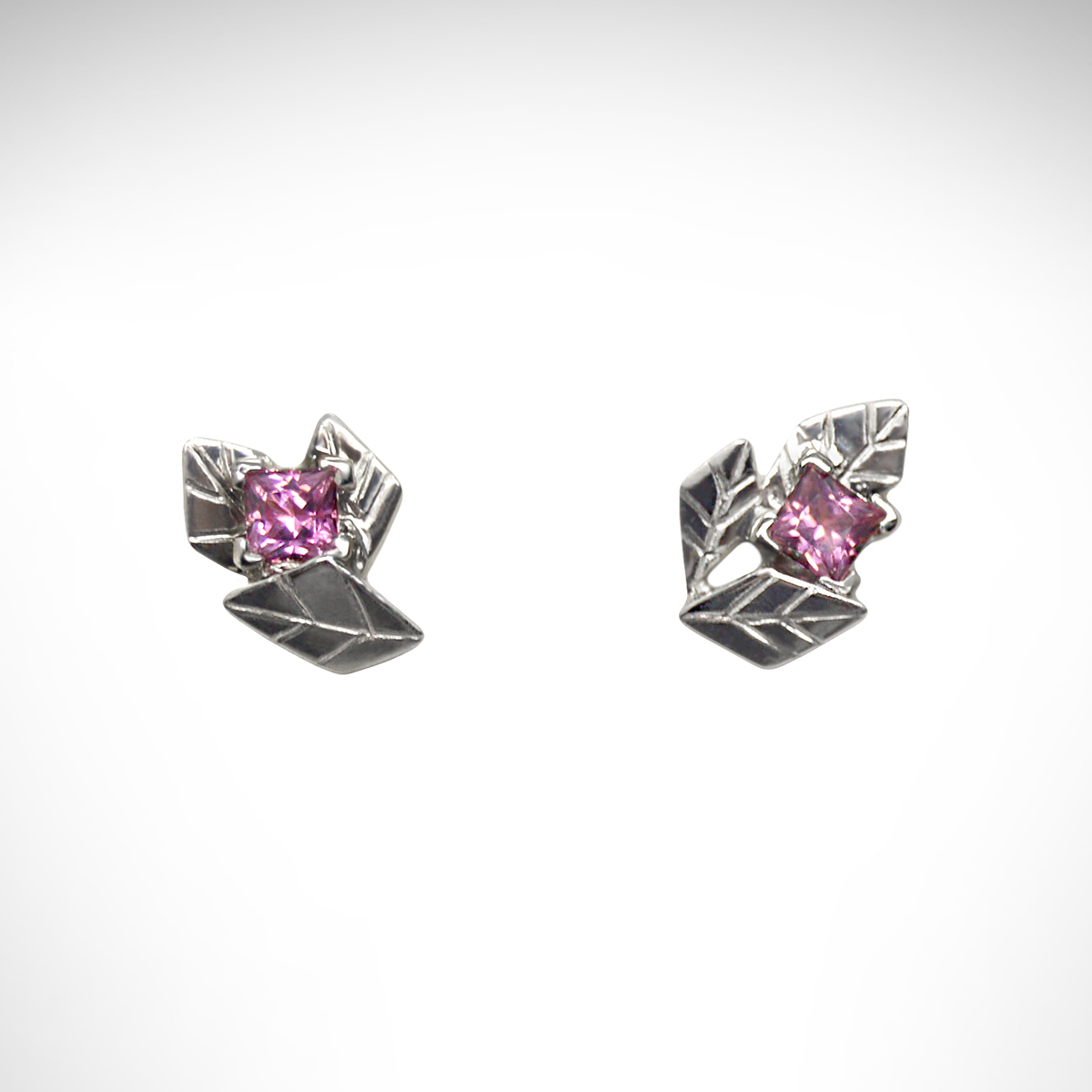 14k white gold stud earrings, carved in the shape of clusters of leaves, set with square-cut pink tourmaline gemstones.